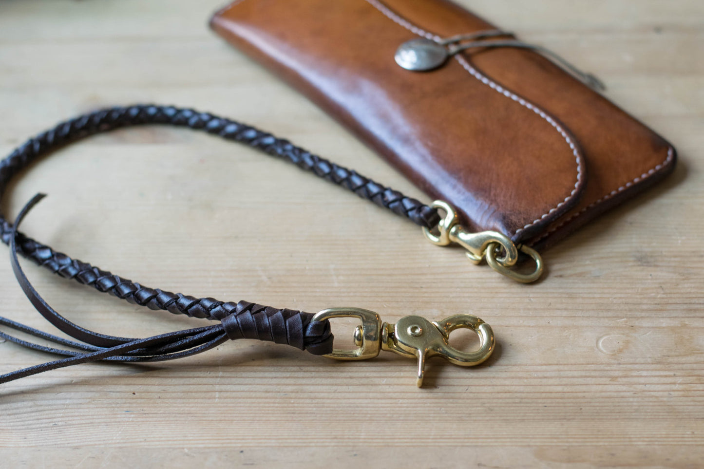 A round braid dark brown vegetable-tanned leather wallet rope with a solid brass trigger snap attached on biker wallet - lifestyle