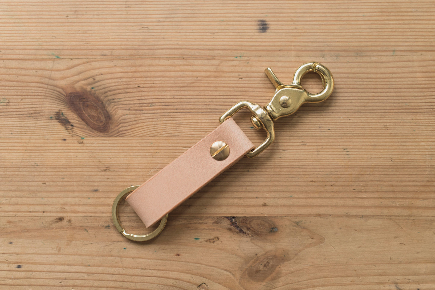 A natural leather key holder with a solid brass Chicago screw and trigger snap, back view