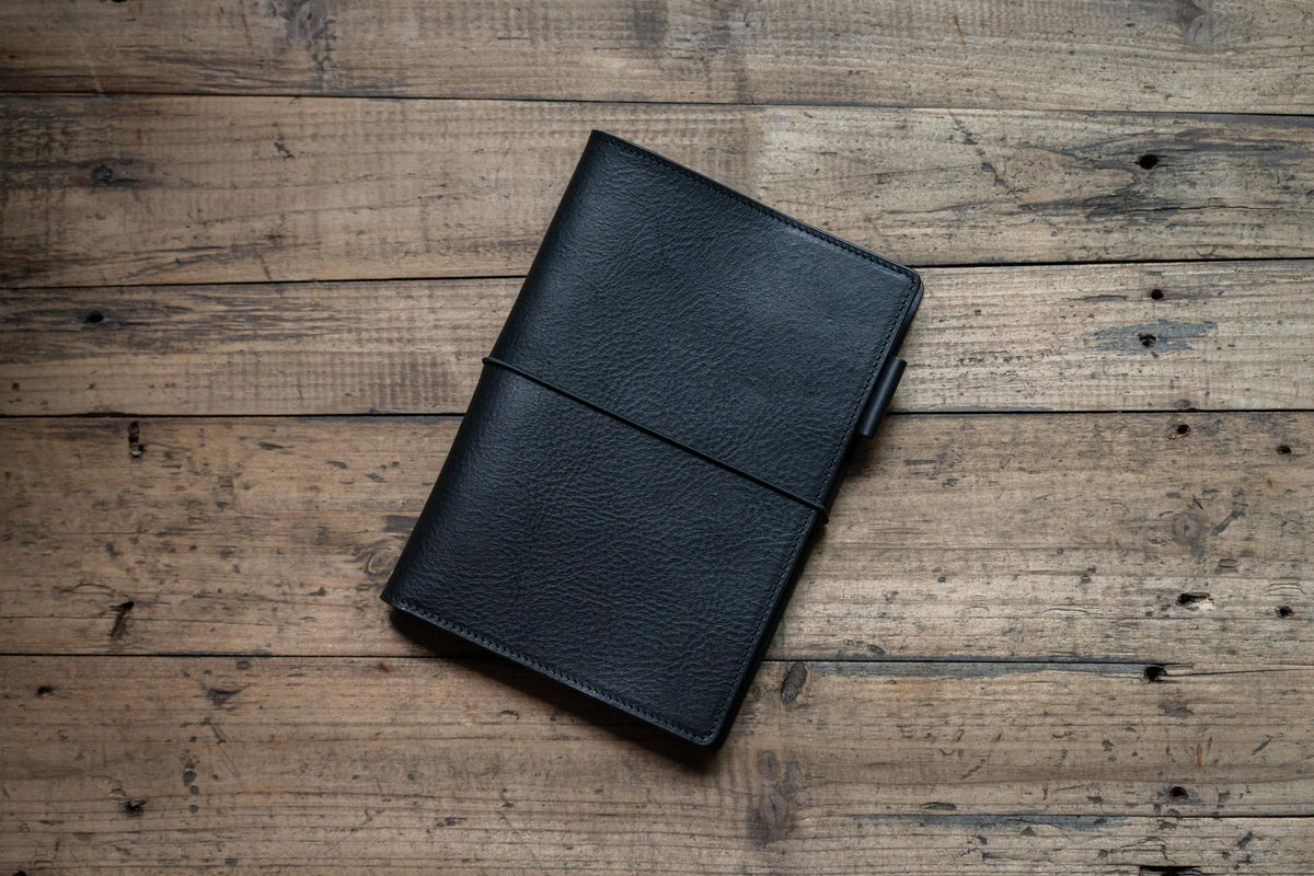 A black leather cover with black elastic bands
