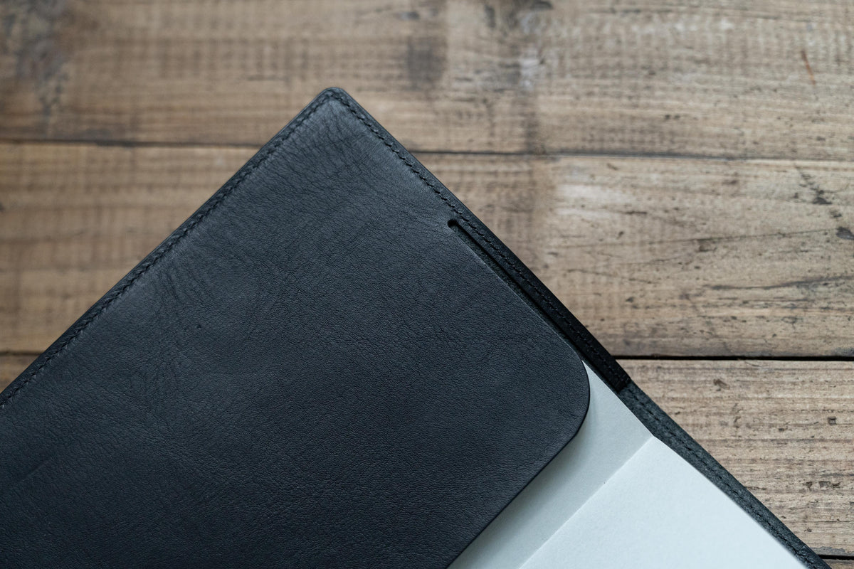 Close up for the left pocket of a black leather notebook cover 