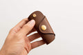 A brown buttero leather key case with brass hardware