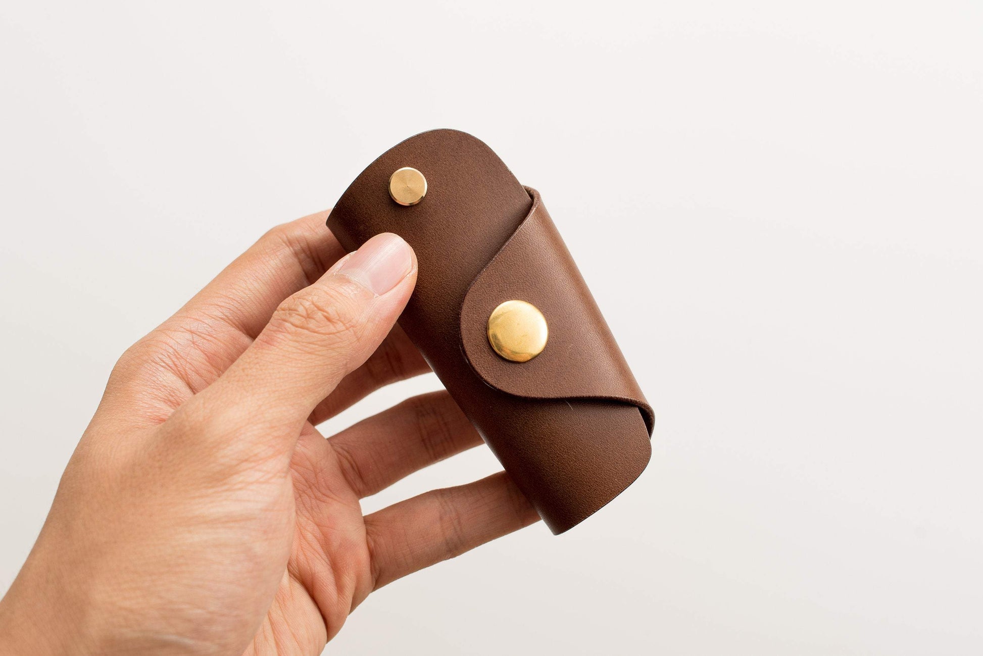 A brown buttero leather key case with brass hardware