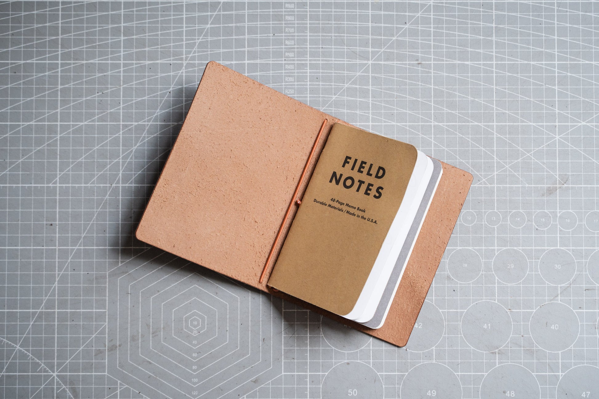 An Field Notes notebook with Dollaro textured leather cover