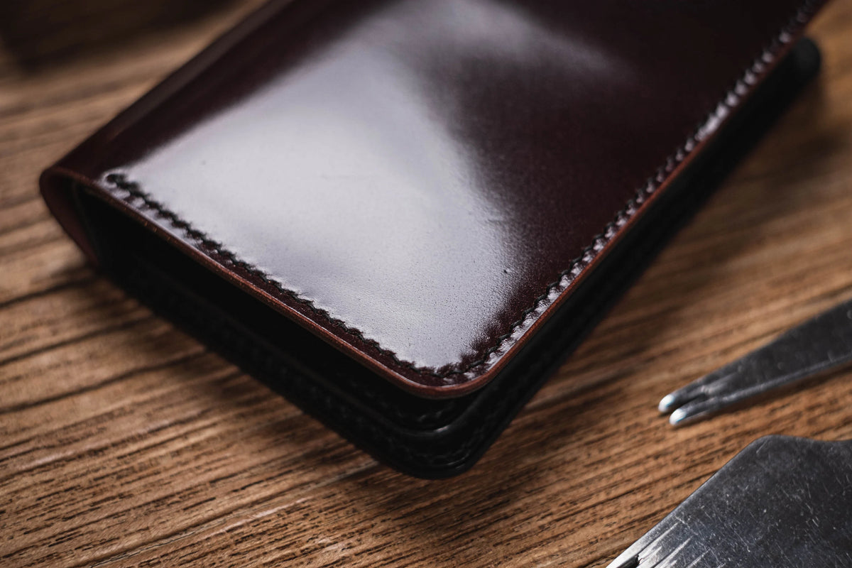 A close-up of a burgundy polished leather wallet 