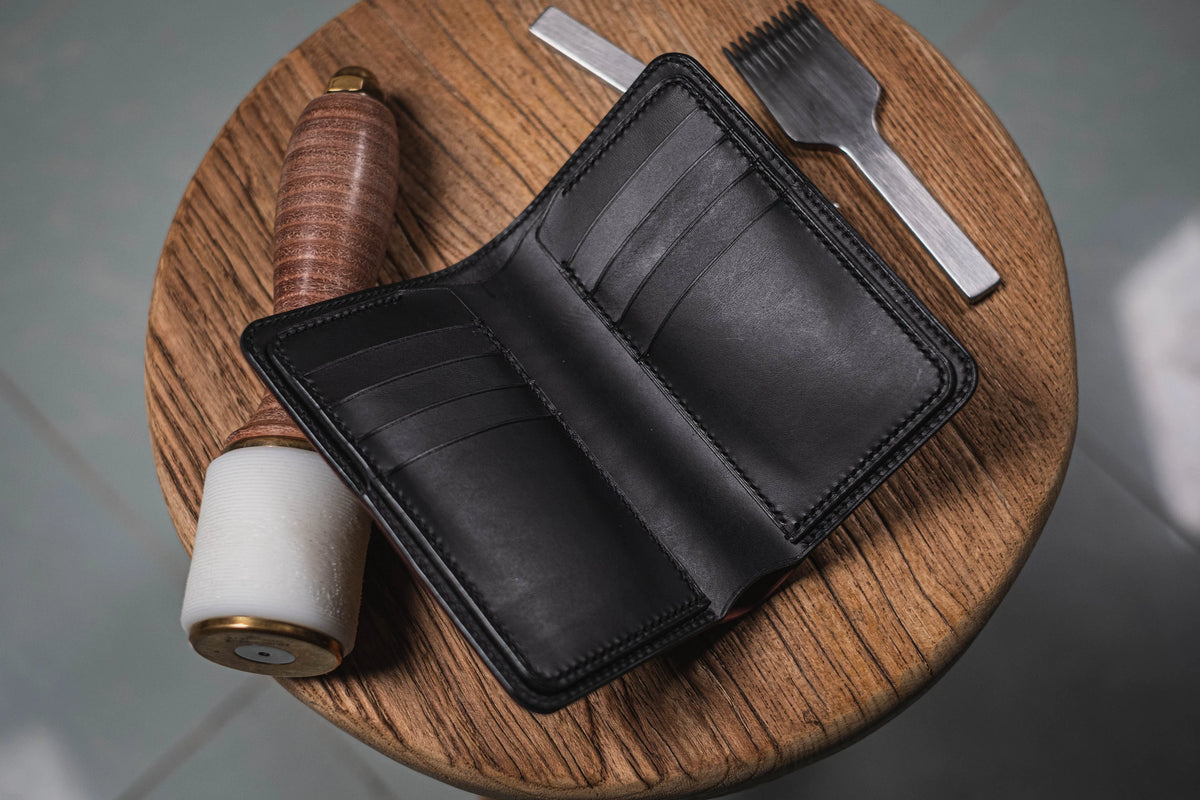 A black leather bifold wallet with 8 card slots is shown open