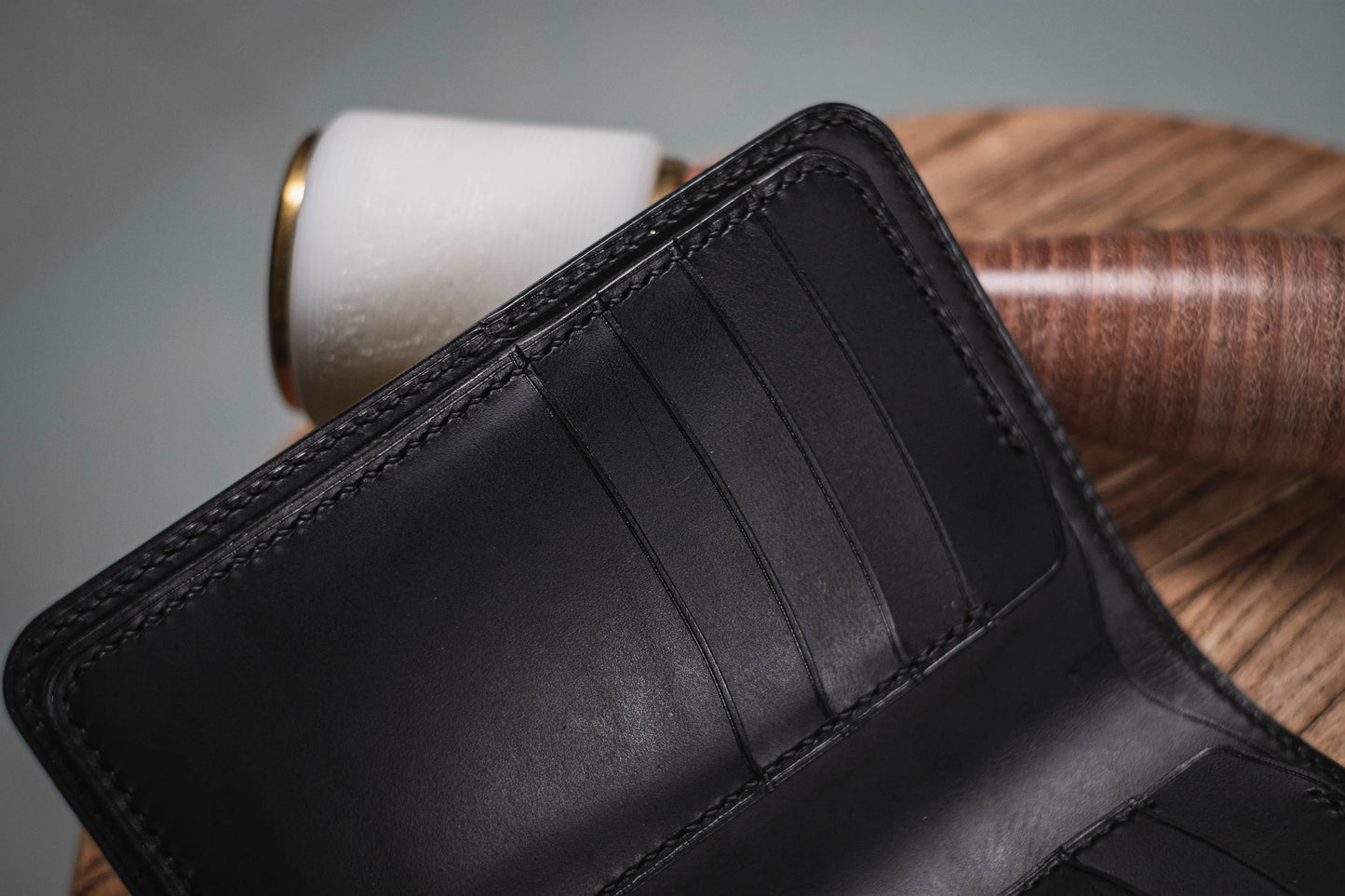 Close-up of an open black leather wallet showing card slots and interior stitching.