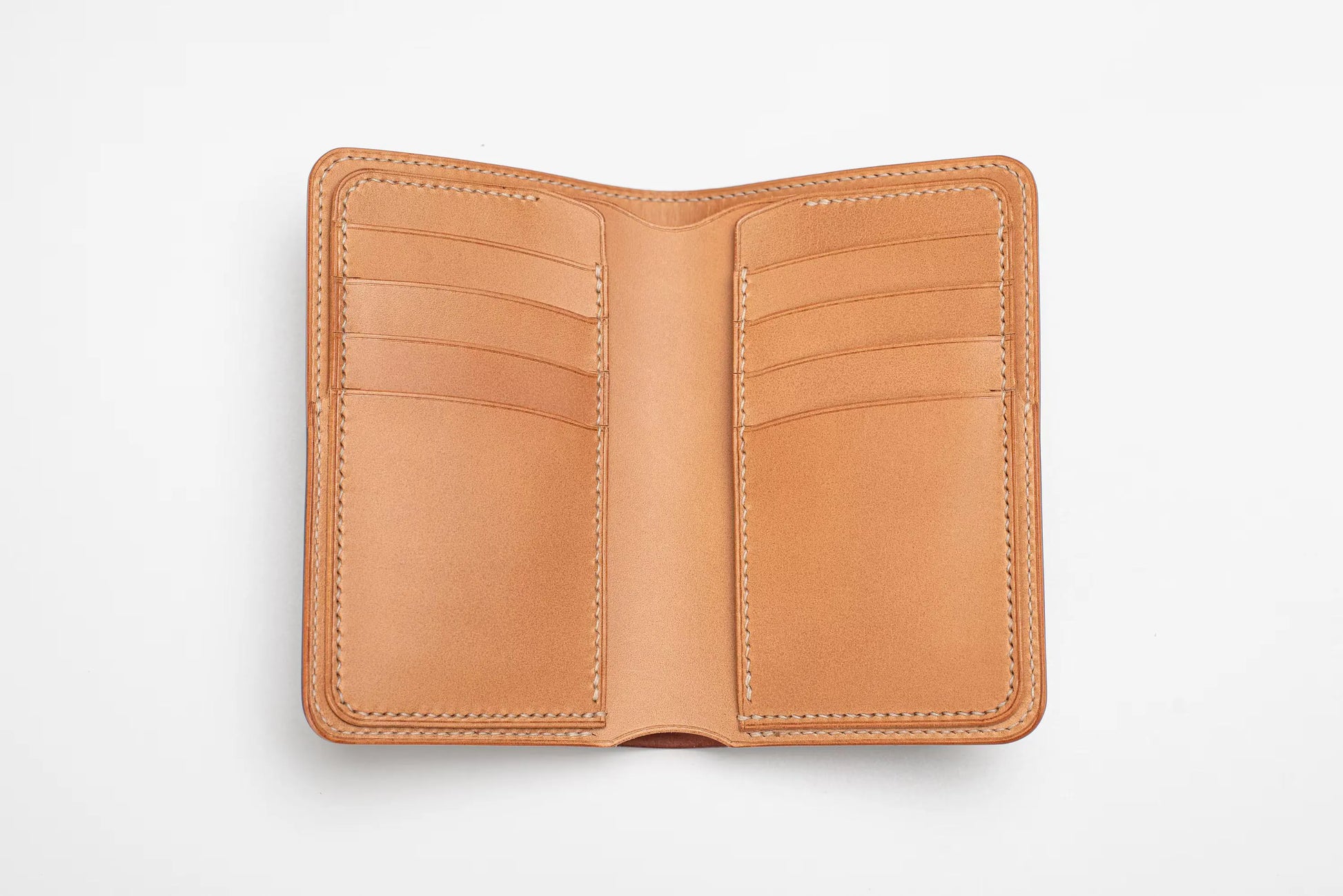 A caramel leather wallet shown open, featuring multiple card slots on both sides