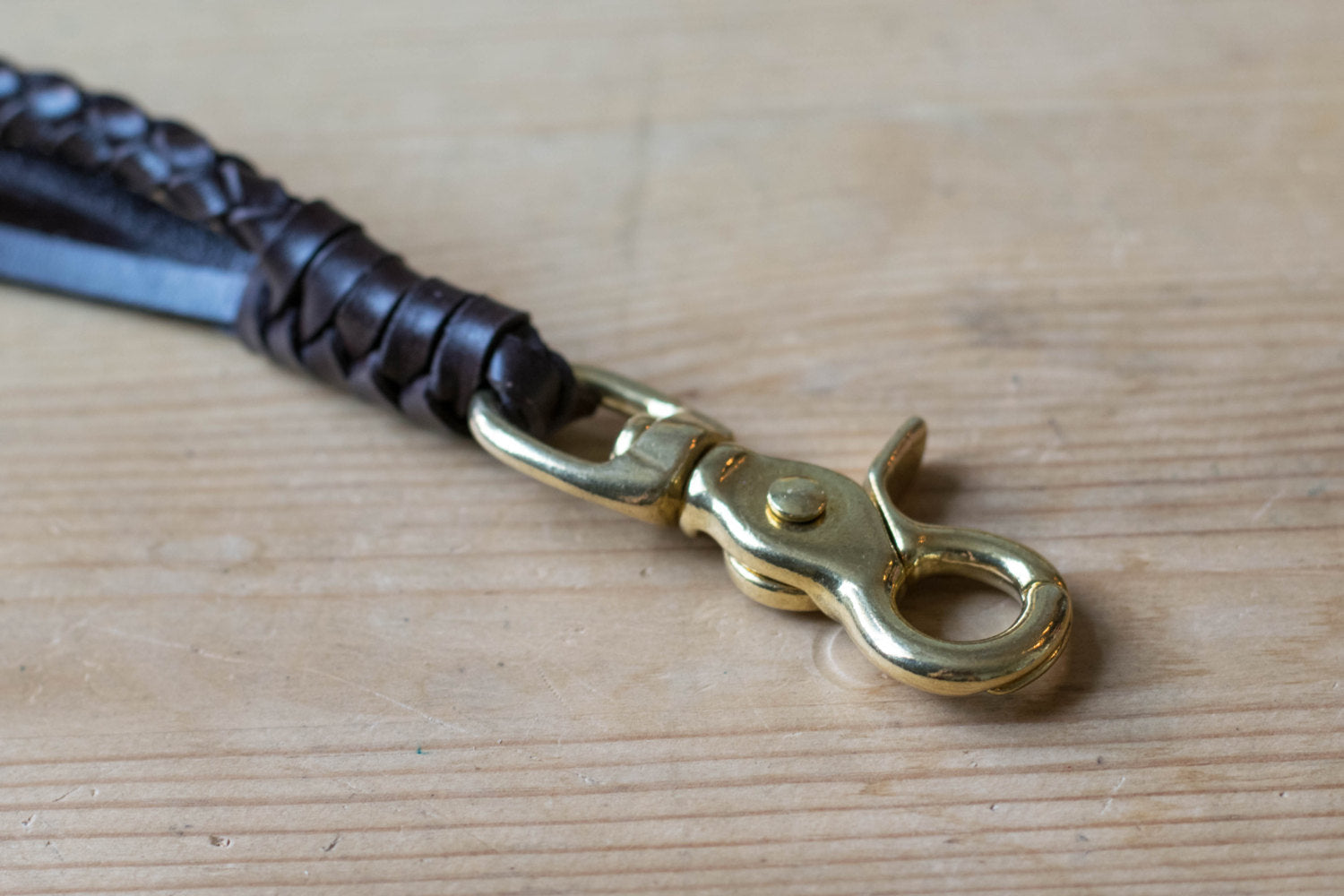 A round braid dark brown vegetable-tanned leather wallet rope with a solid brass trigger snap - close up for solid brass trigger snap