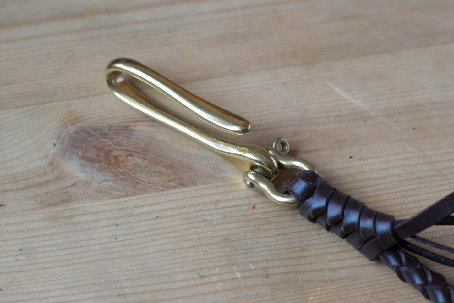 A round braid dark brown vegetable-tanned leather wallet rope with a solid brass hook - close up for the solid brass fish hook 