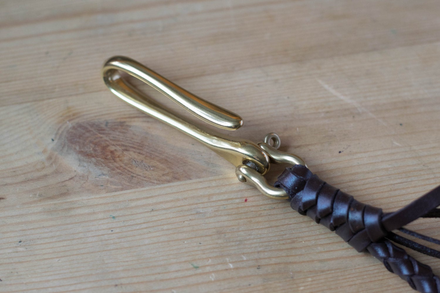 A round braid dark brown vegetable-tanned leather wallet rope with a solid brass hook - close up for the solid brass fish hook 