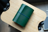 Green Buttero Leather Trifold Traveler's Notebook Cover with blue elastic