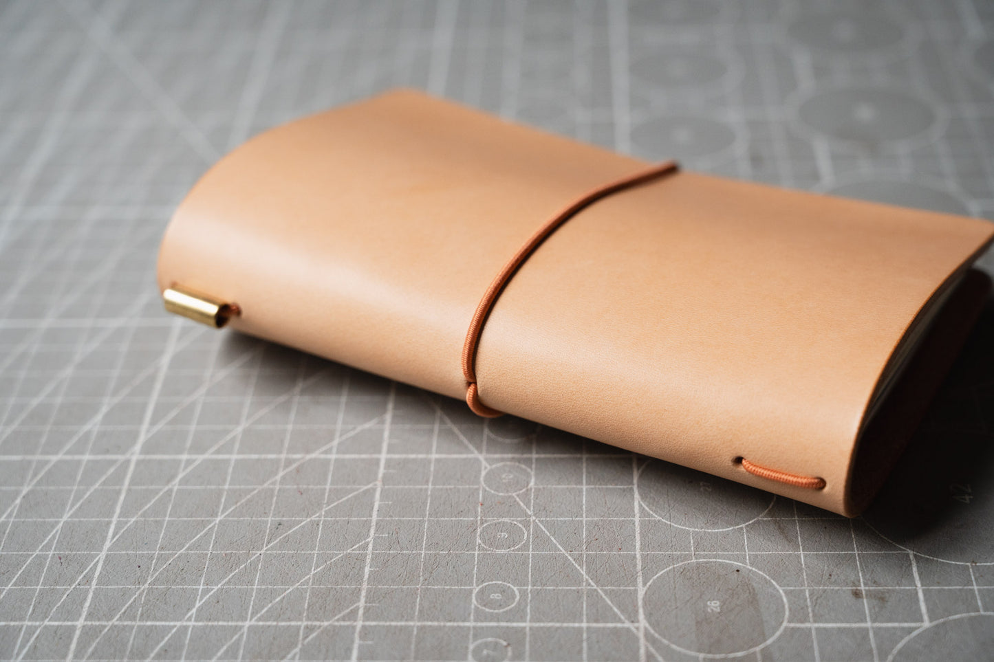 The spine of a light tan leather notebook cover