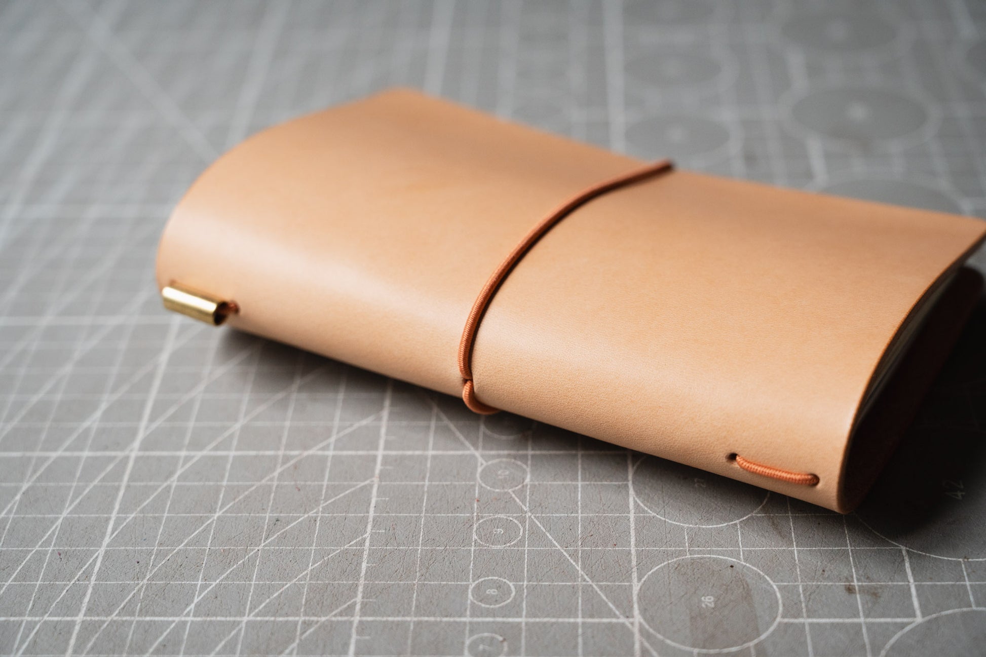 The spine of a light tan leather notebook cover