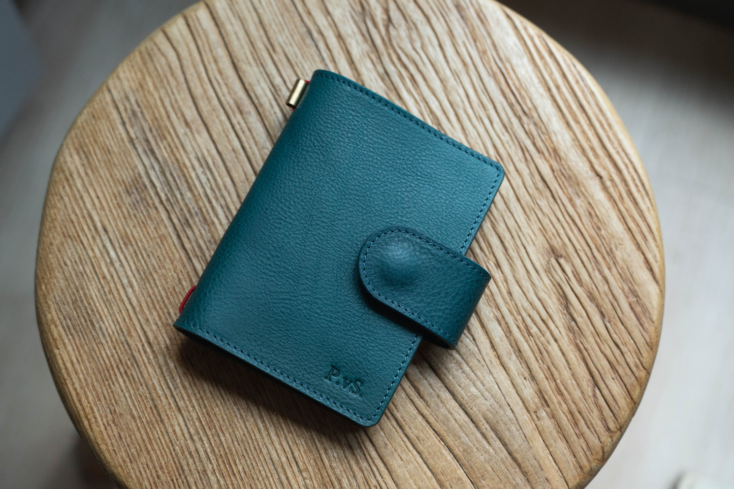A navy blue pebbled leather traveler's notebook with a strap closure, displayed closed