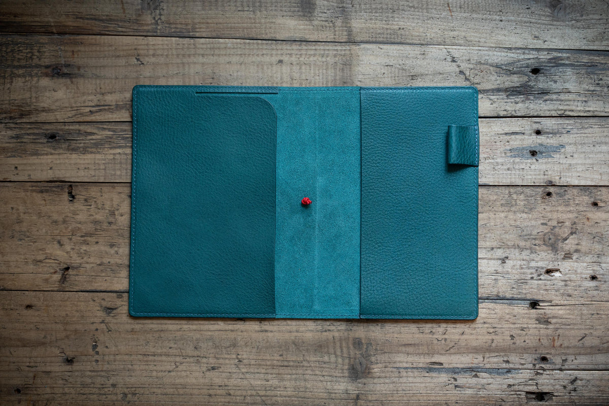 A navy blue leather notebook cover displayed open.