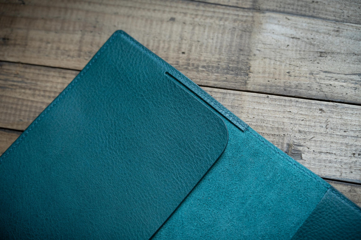 Close up for the stitched edge of a navy blue leather notebook cover 