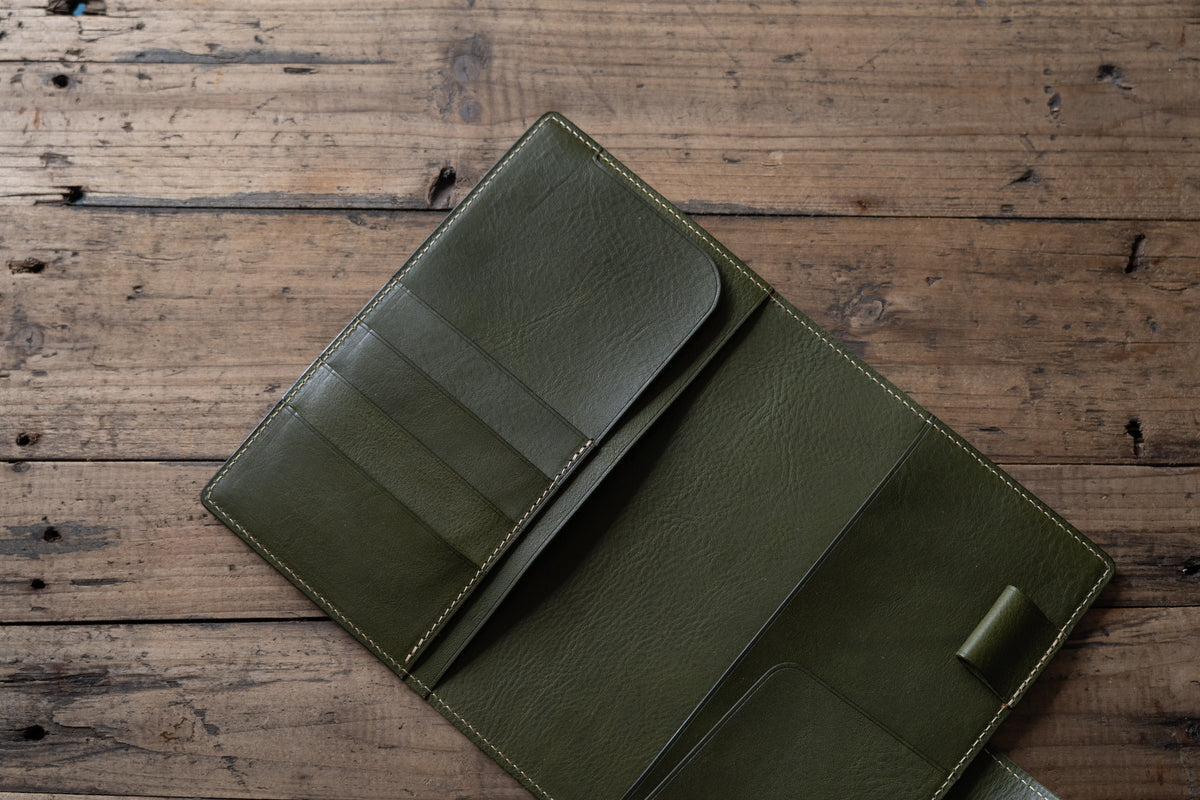 A olive green pebbled leather notebook folio cover with card slots and a snap closure, displayed open.