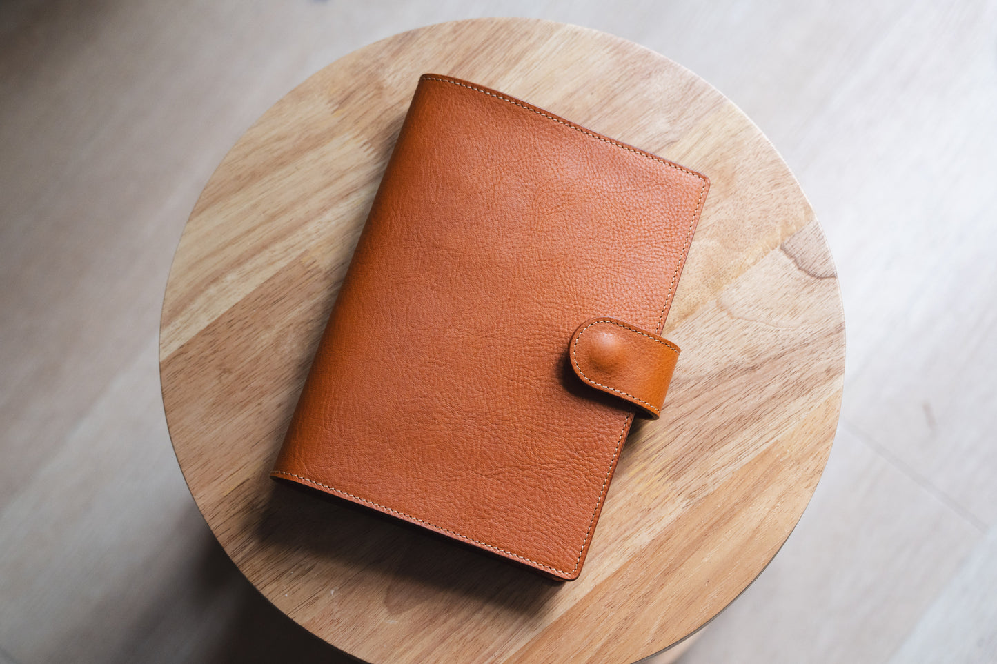 A orange brown leather notebook cover with a textured grain finish. 