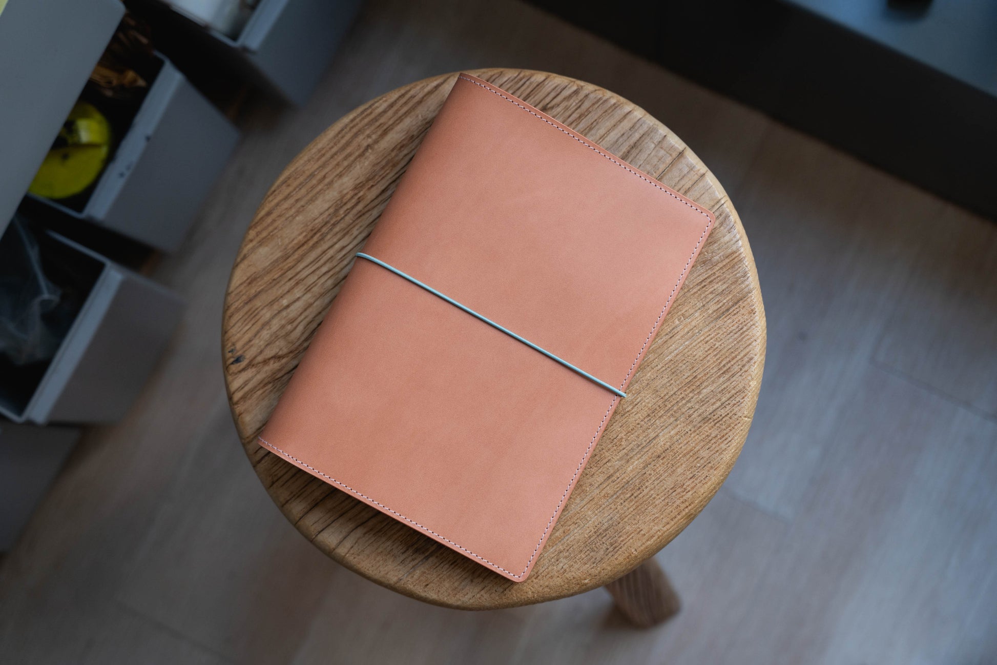 A leather notebook cover in pink color with elastic closure