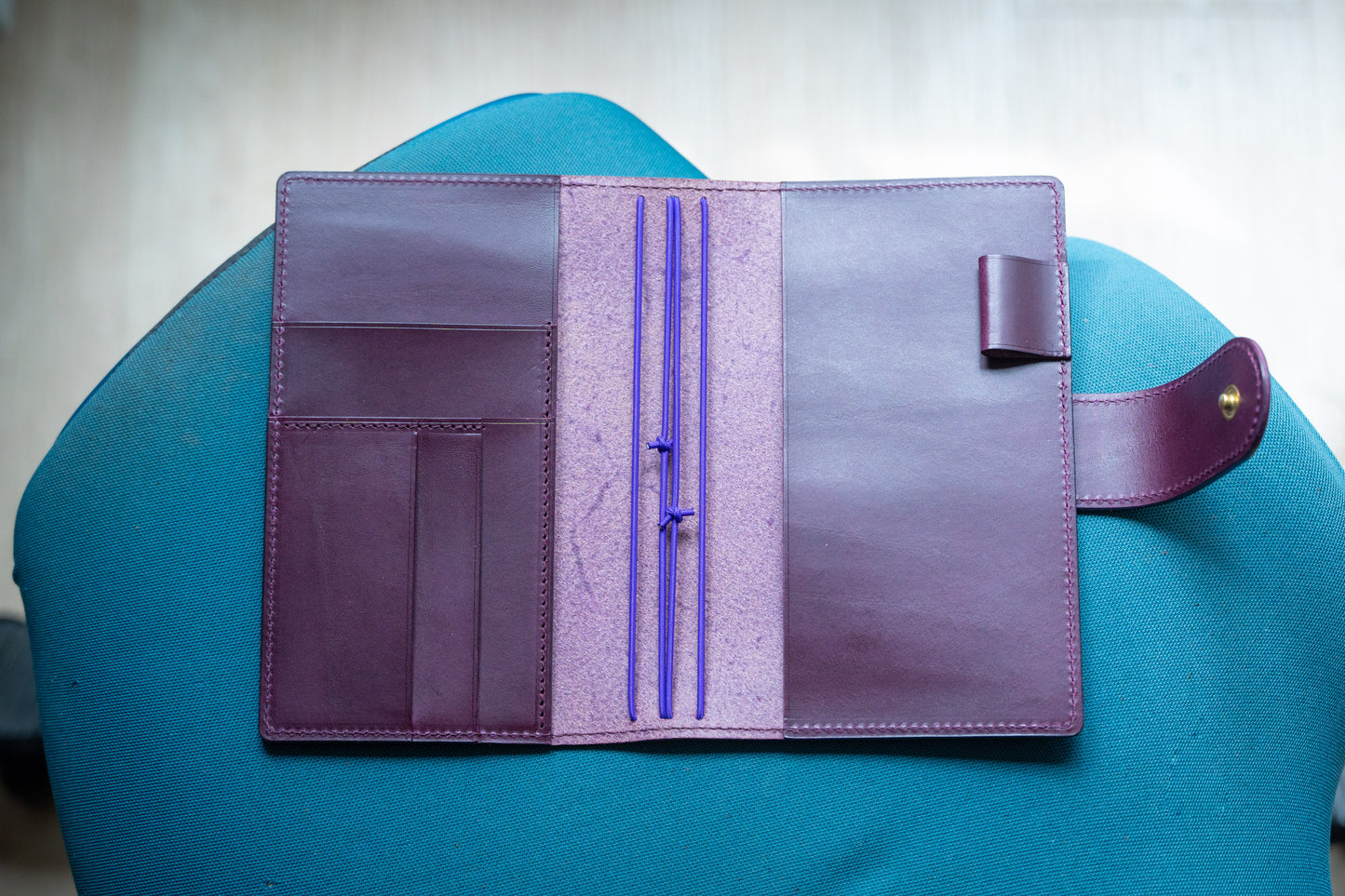 A burgundy Stitched Buttero Leather Traveler's Notebook with Card Slots and elastic strands and pen loop, displayed open