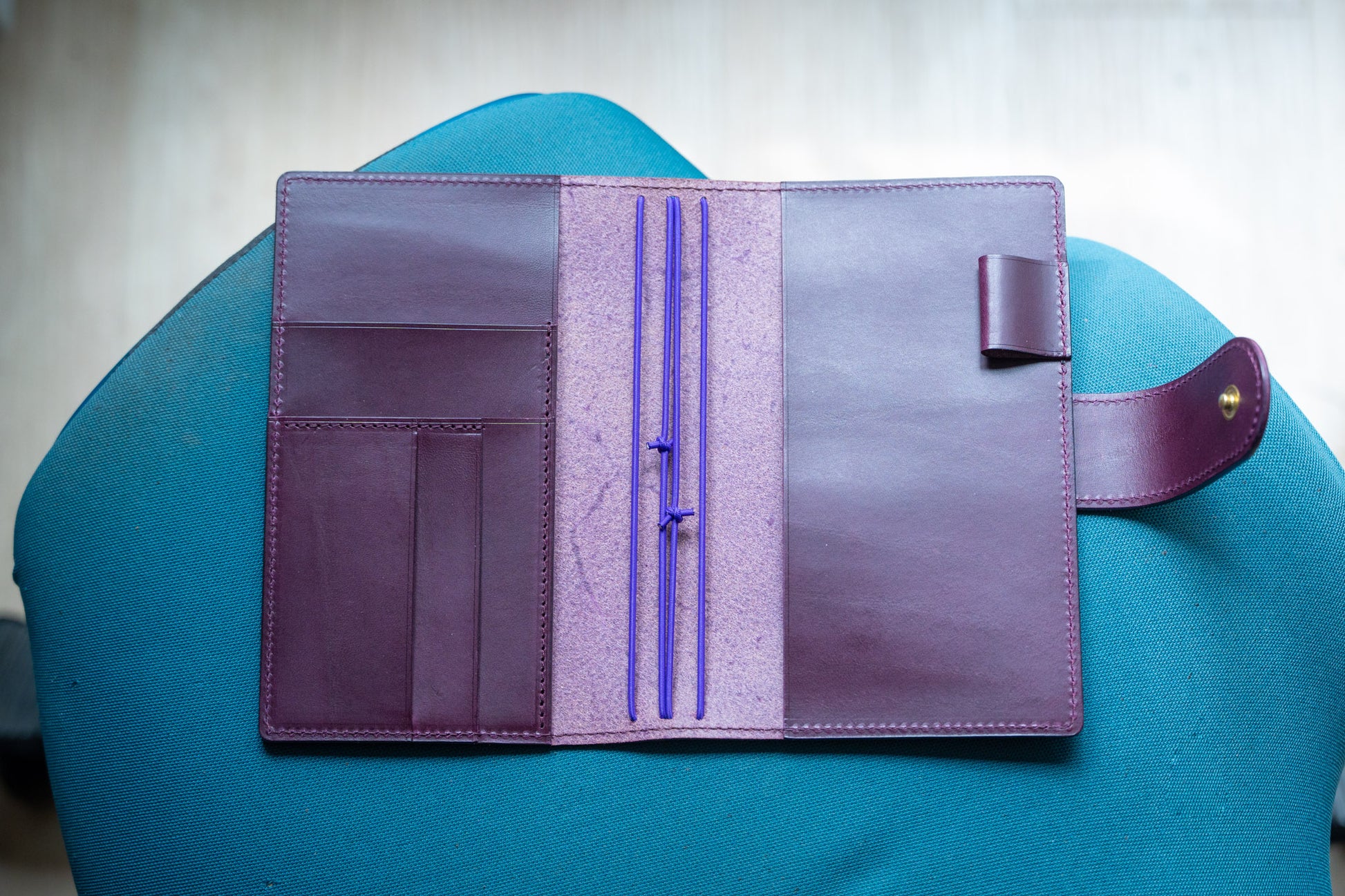 A burgundy Stitched Buttero Leather Traveler's Notebook with Card Slots and elastic strands and pen loop, displayed open