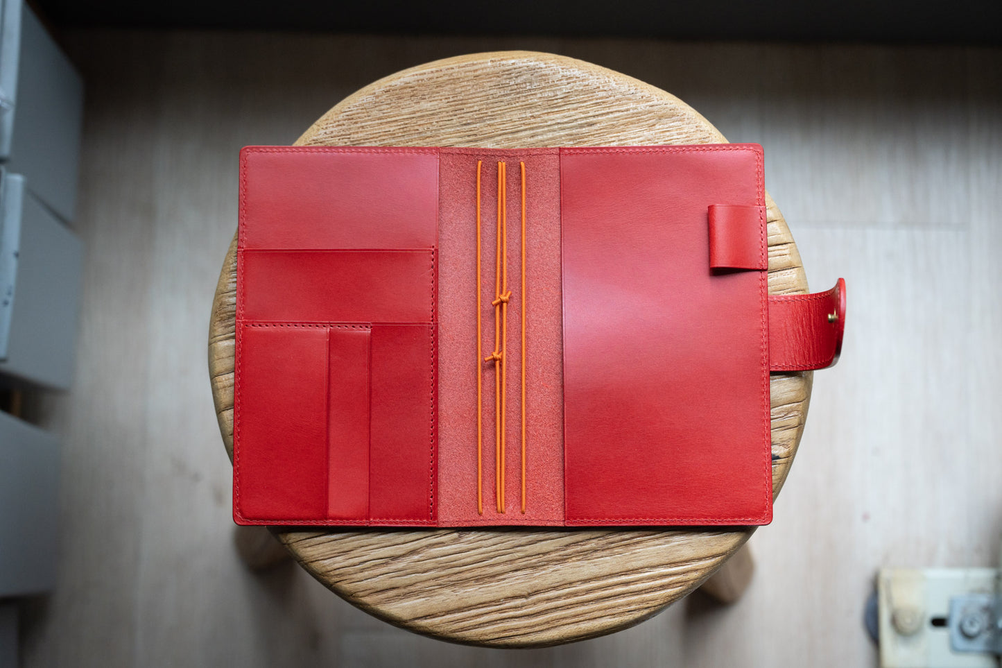 A red Stitched Buttero Leather Traveler's Notebook with Card Slots and elastic strands and pen loop, displayed open