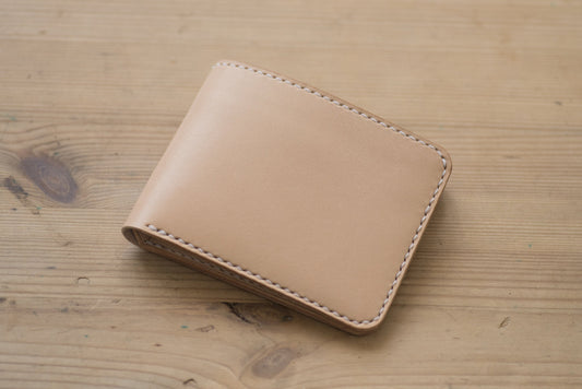 A natural leather wallet with white stitching around the edges.