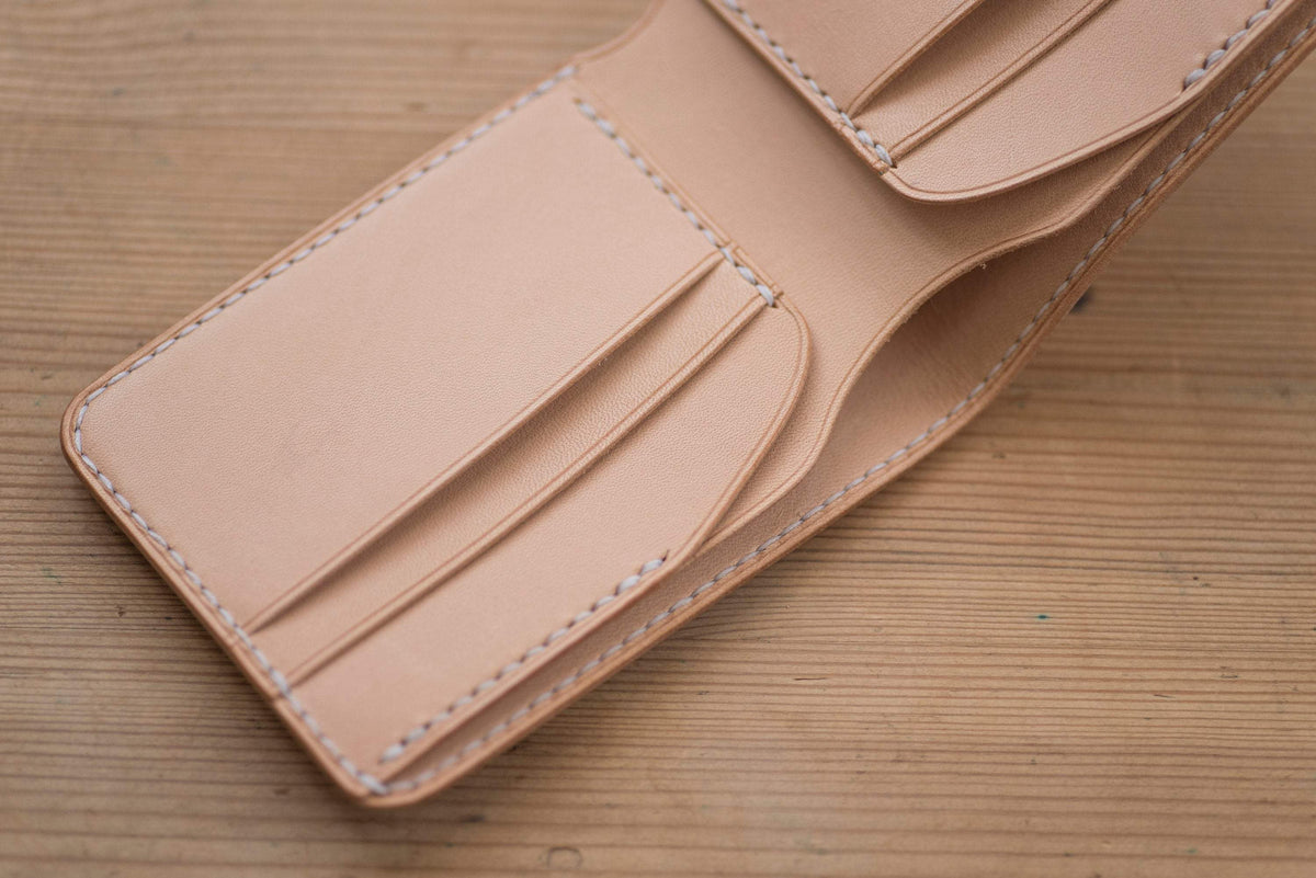 A natural leather wallet with 4 card slots and a stitched edge - close up card slots