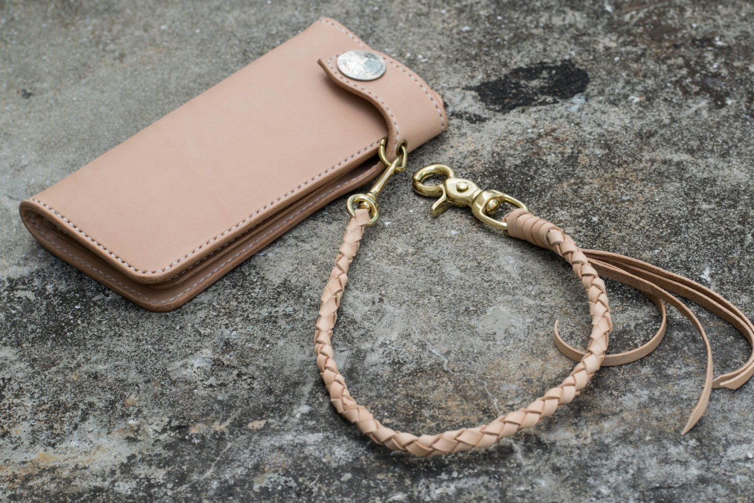 A round braid natural vegetable-tanned leather wallet rope with a solid brass trigger snap attached on biker wallet - lifestyle
