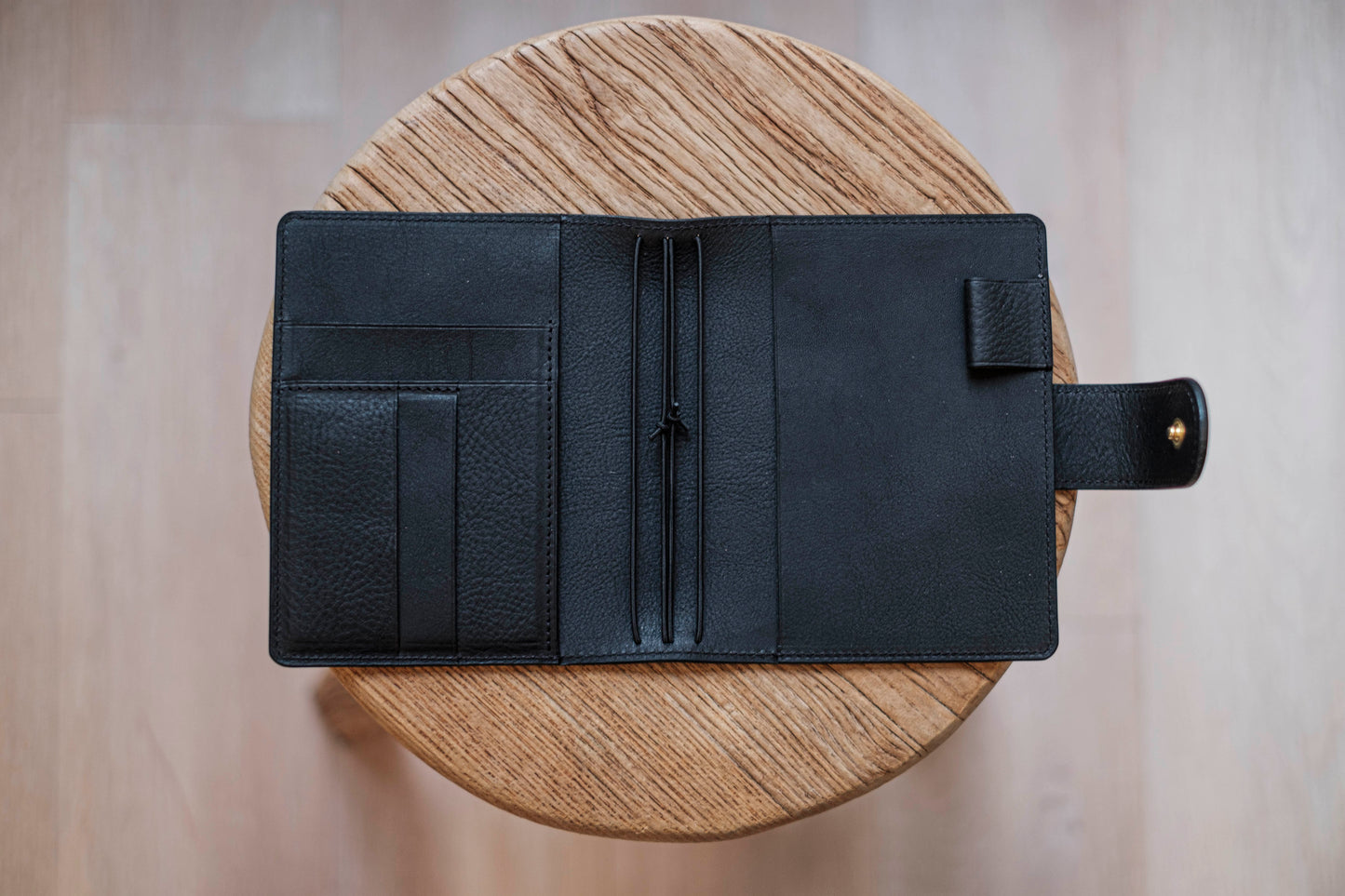 A olive green lined traveler's notebook with card slots and a leather strap, displayed open - detail