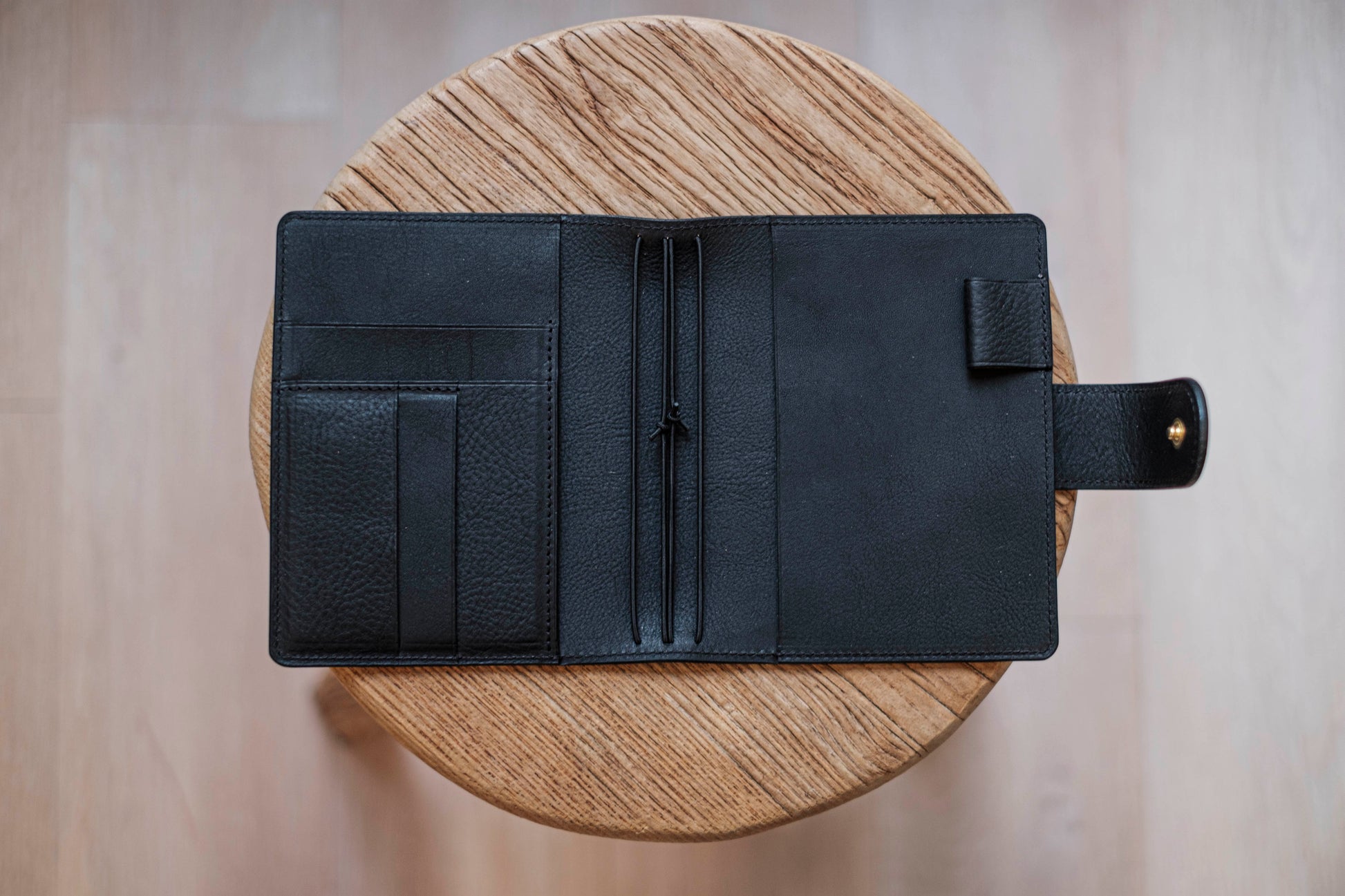 A olive green lined traveler's notebook with card slots and a leather strap, displayed open - detail