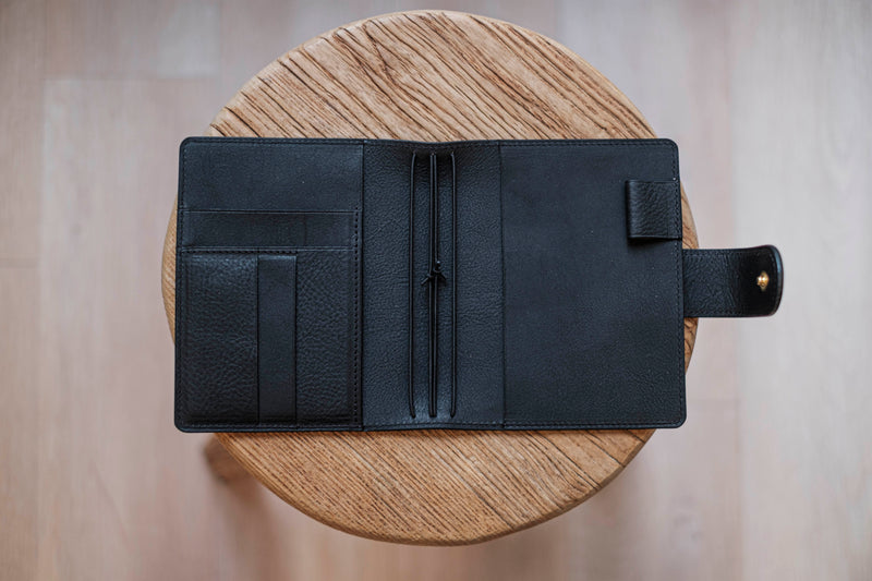 A olive green lined traveler's notebook with card slots and a leather strap, displayed open - detail