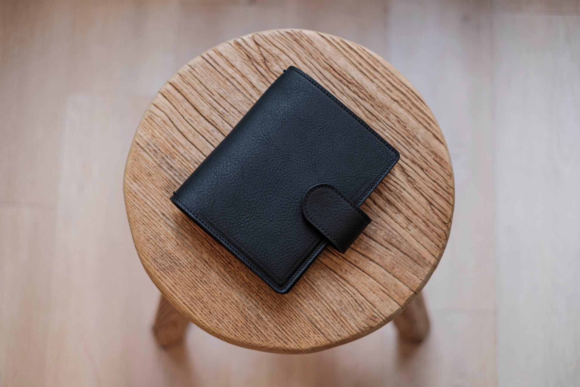 A black lined traveler's notebook with card slots and a leather strap, displayed close
