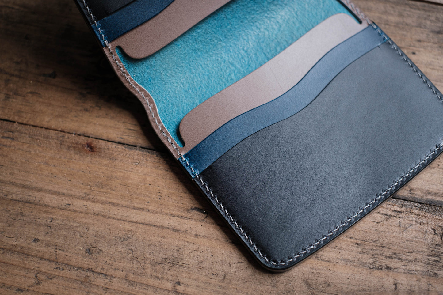 A blue leather wallet with multiple card slots and a stitched edge.