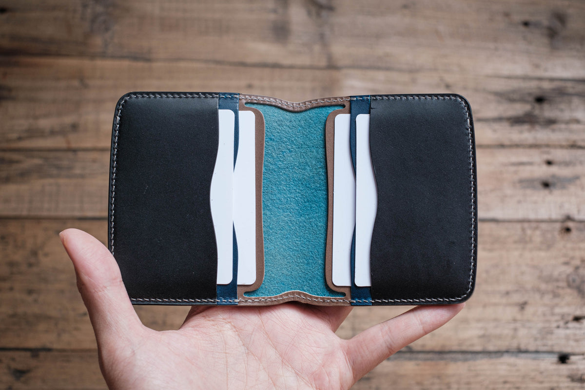 A black leather card holder with a blue leather interior and multiple card slots.