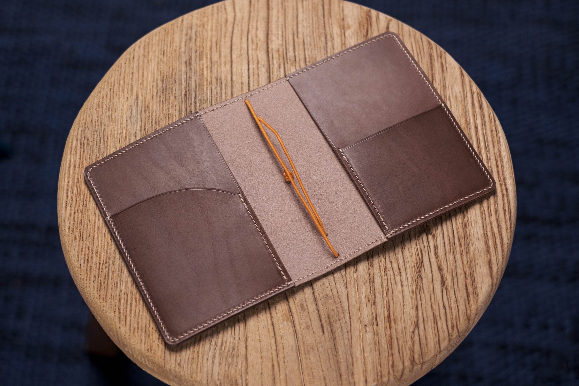 A brown Stitched Buttero Leather Traveler's Notebook and a elastic enclouse, displayed open, show the pocket and elastic strands