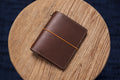 A brown Stitched Buttero Leather Traveler's Notebook and a elastic enclouse, displayed close