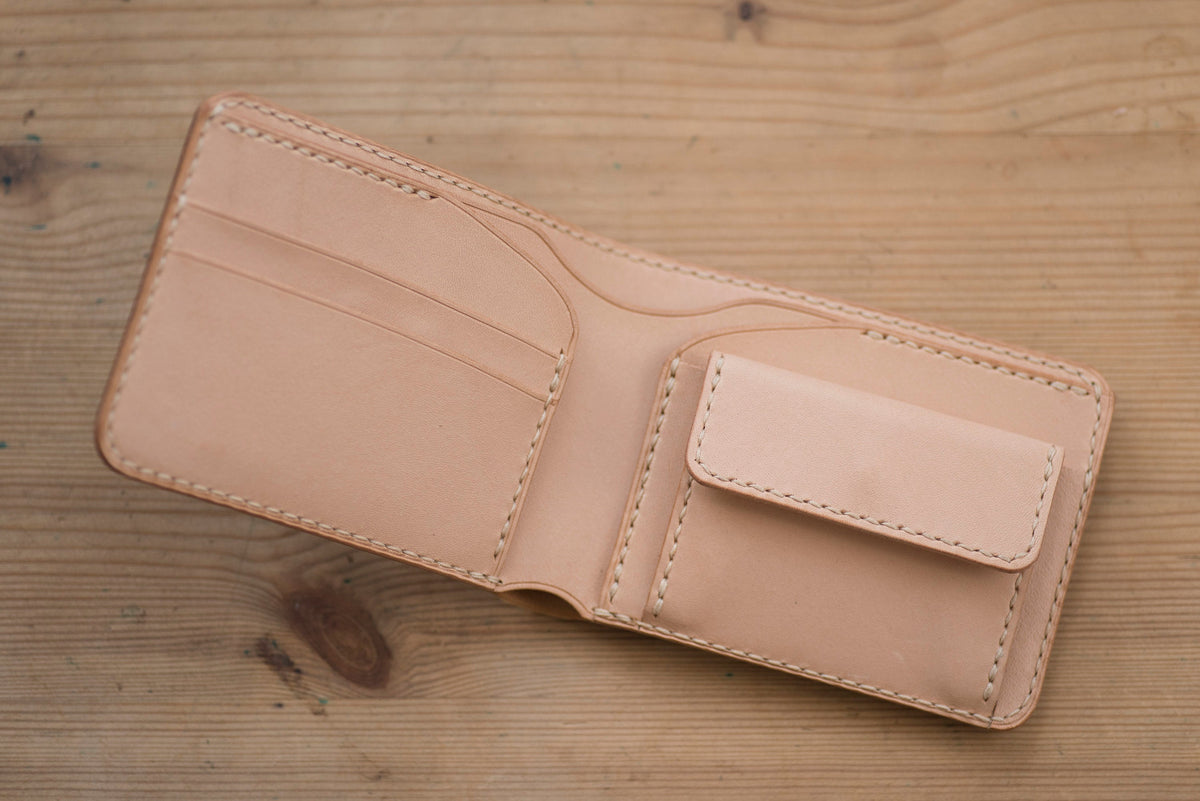 A natural leather wallet with 2 card slots and a billfold. The wallet is open and the interior is visible.