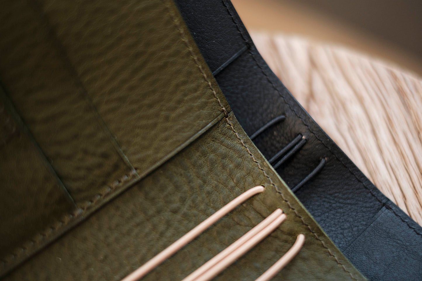 Two lined traveler's notebook with card slots and a leather strap -Close up of rich textured grain and stitching