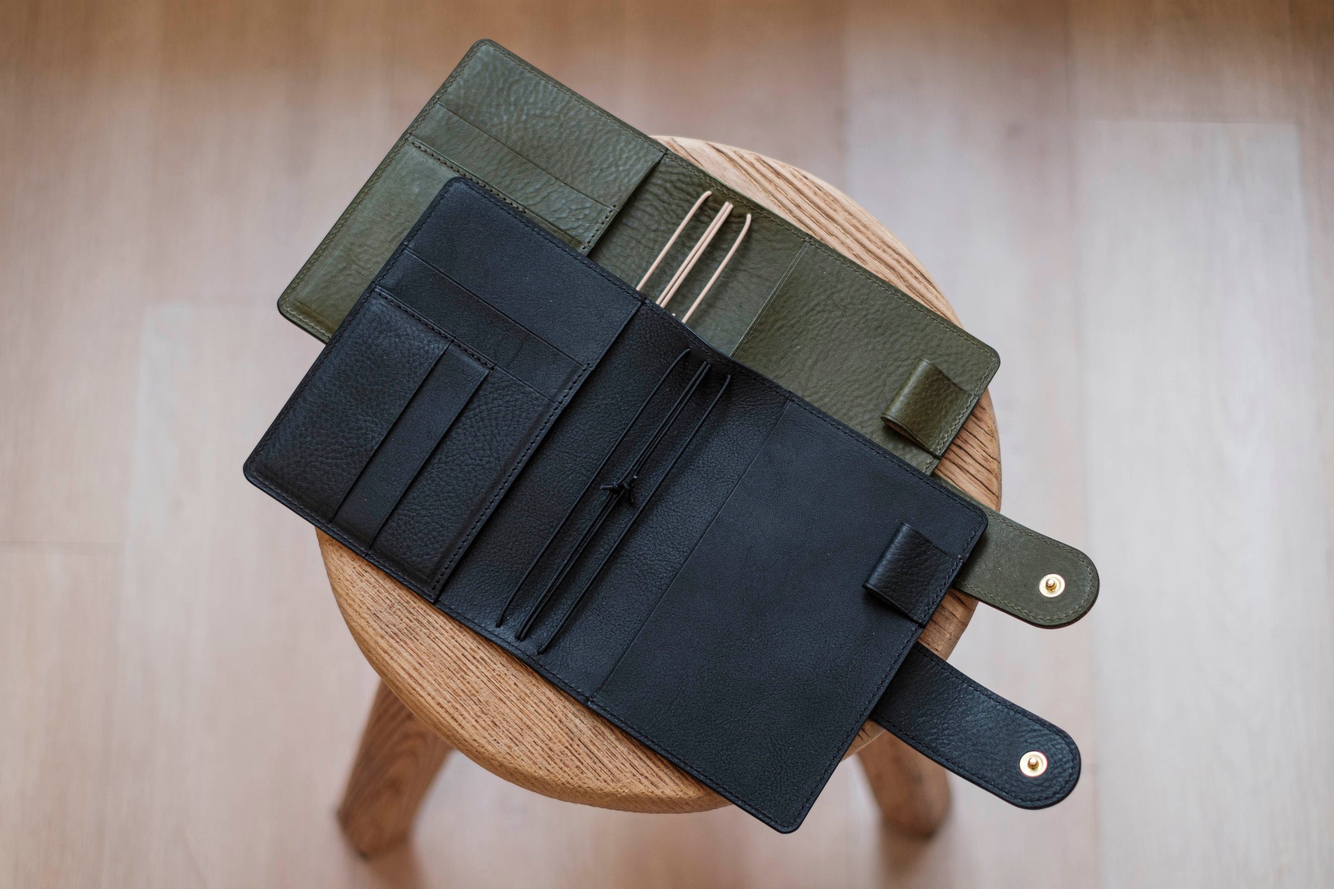Two lined traveler's notebook with card slots and a leather strap, displayed open 