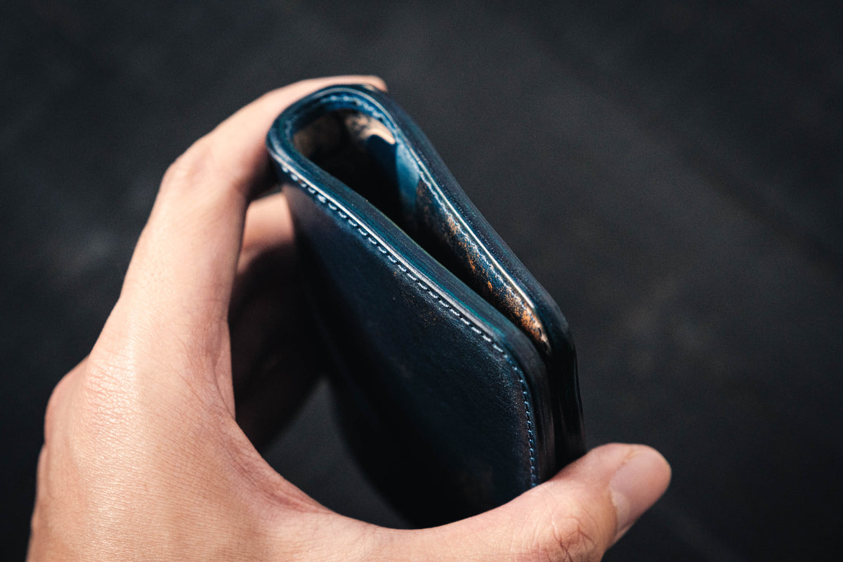 A person holding a blue Rocado Shell Cordovan Contour Billfold Wallet