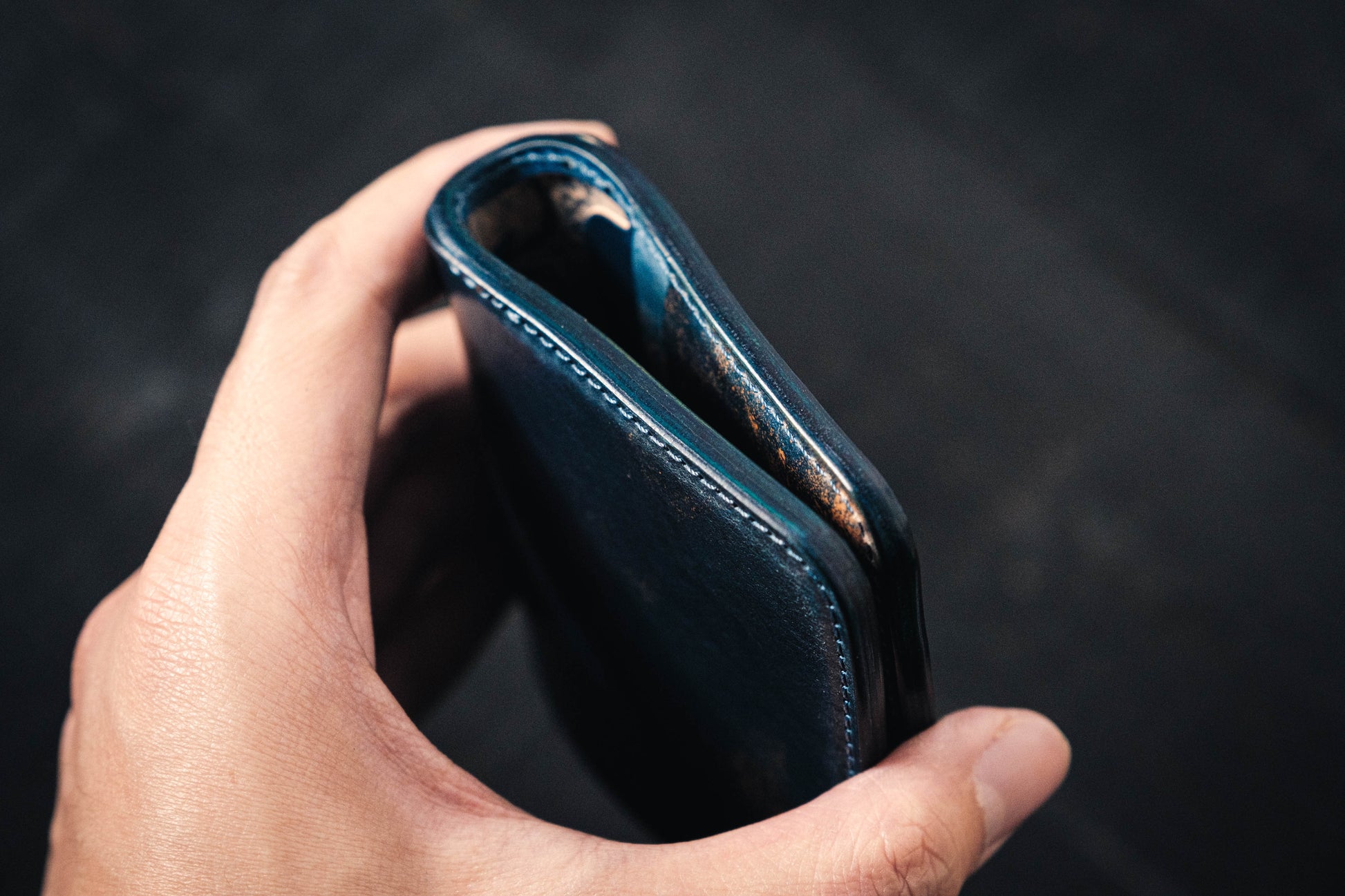 A person holding a blue Rocado Shell Cordovan Contour Billfold Wallet