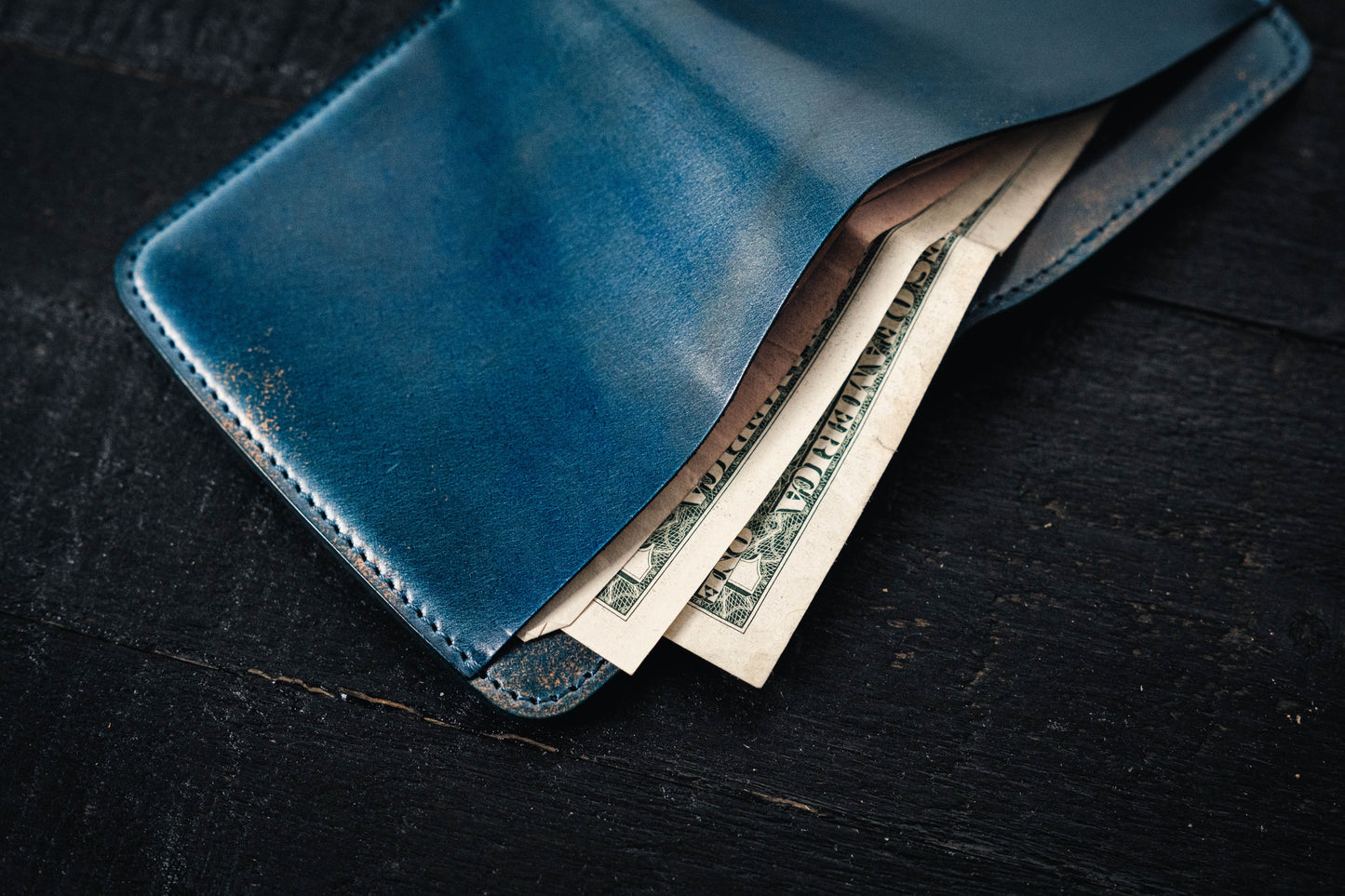a blue Rocado Shell Cordovan Contour Billfold Wallet display opened with cash 