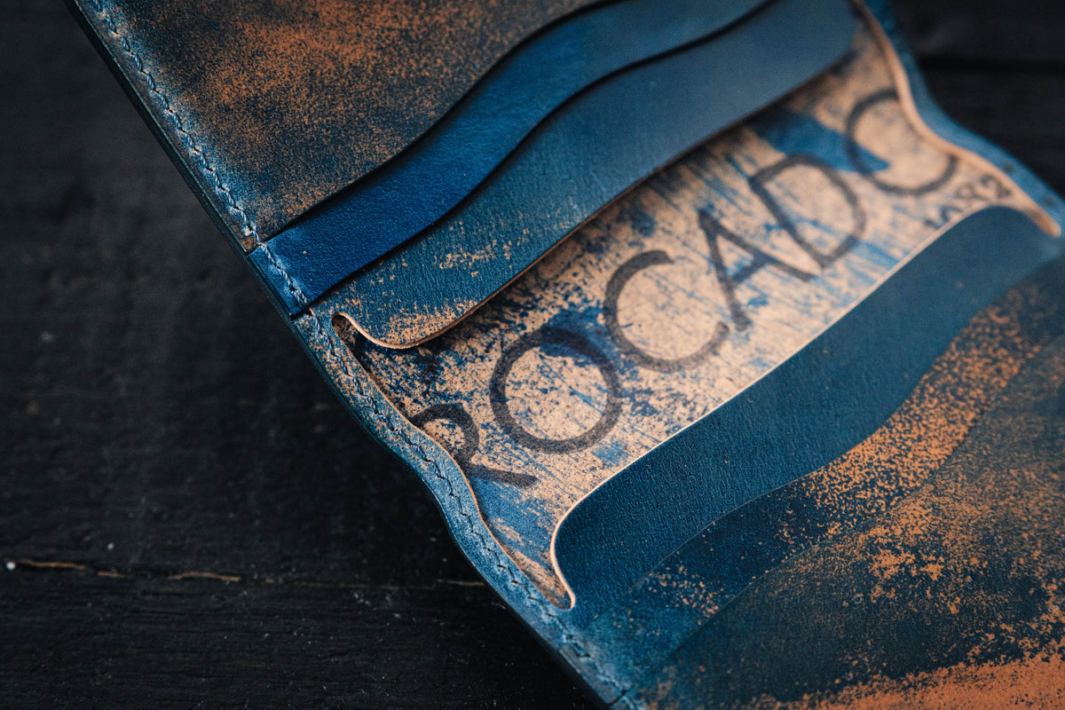 a blue Rocado Shell Cordovan Contour Billfold Wallet display opened - close up the detail "ROCADO"