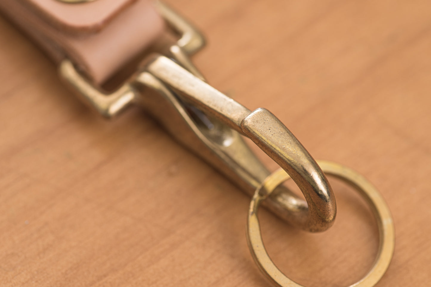 A natural leather key holder with a solid brass hardware and snap, close up of  solid brass snap