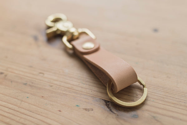A natural leather key holder with a solid brass Chicago screw and trigger snap, close up of the key ring.