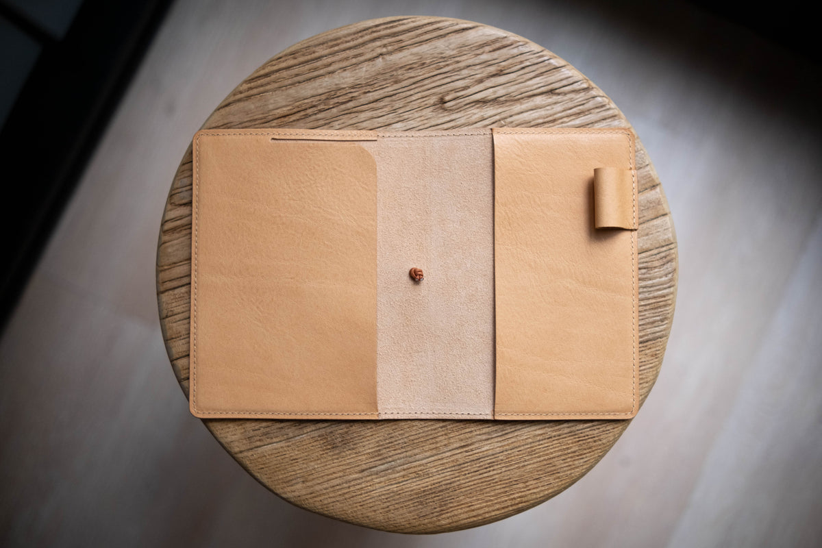 A natural leather notebook cover with a pen holder. 