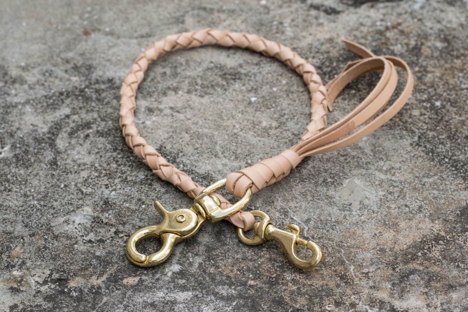 A round braid natural vegetable-tanned leather wallet rope with a solid brass trigger snap 