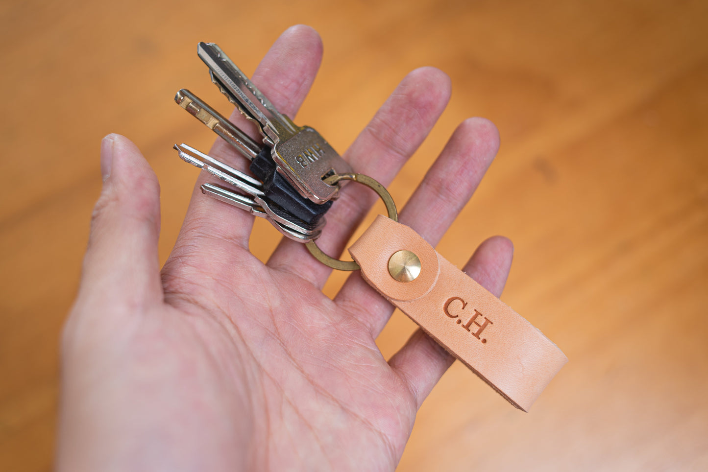 Natural Personalizable Leather Key Fob key holder with solid brass key ring and screws with keys on it - Lifestyle view