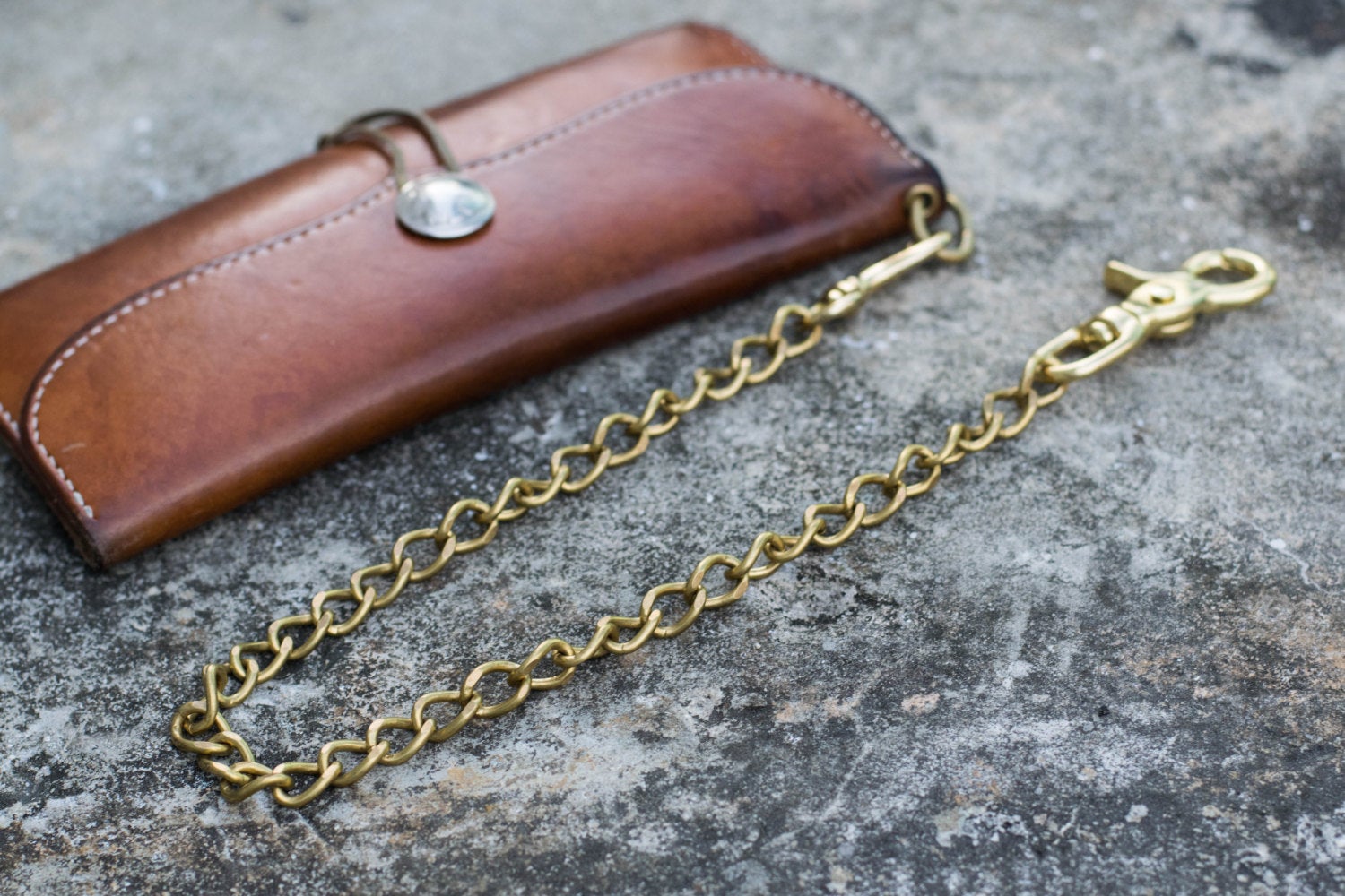 A solid brass wallet chain with a trigger snap attached to long wallet - lifestyle 
